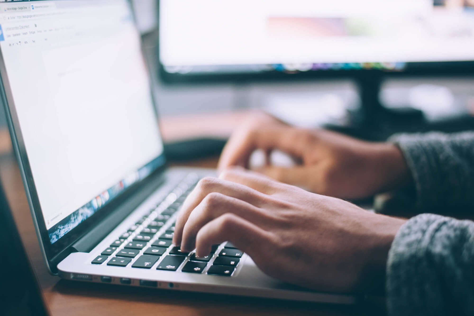 hands type on laptop keyboard