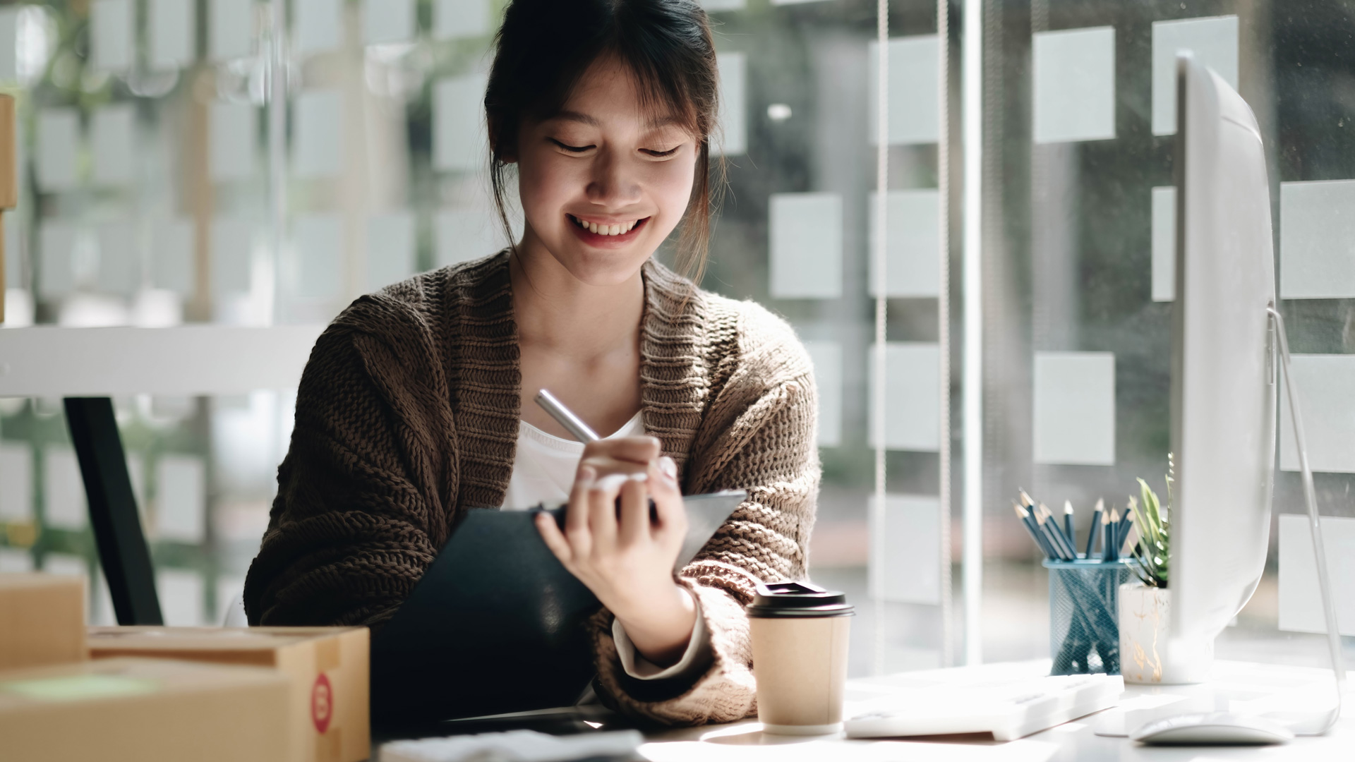 A woman writes on her iPad using her Apple pencil