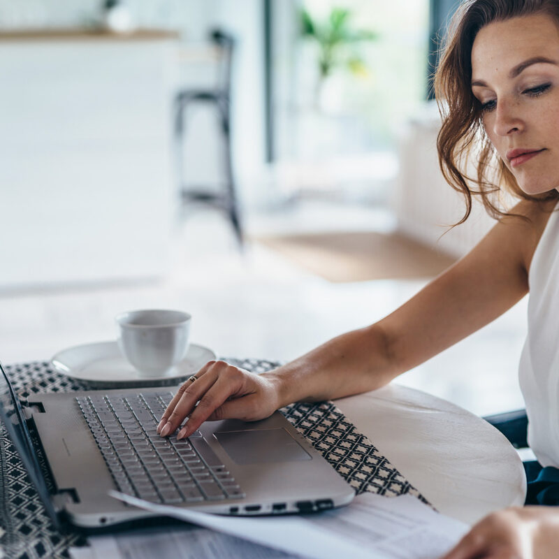 A content marketer types on a laptop keyboard