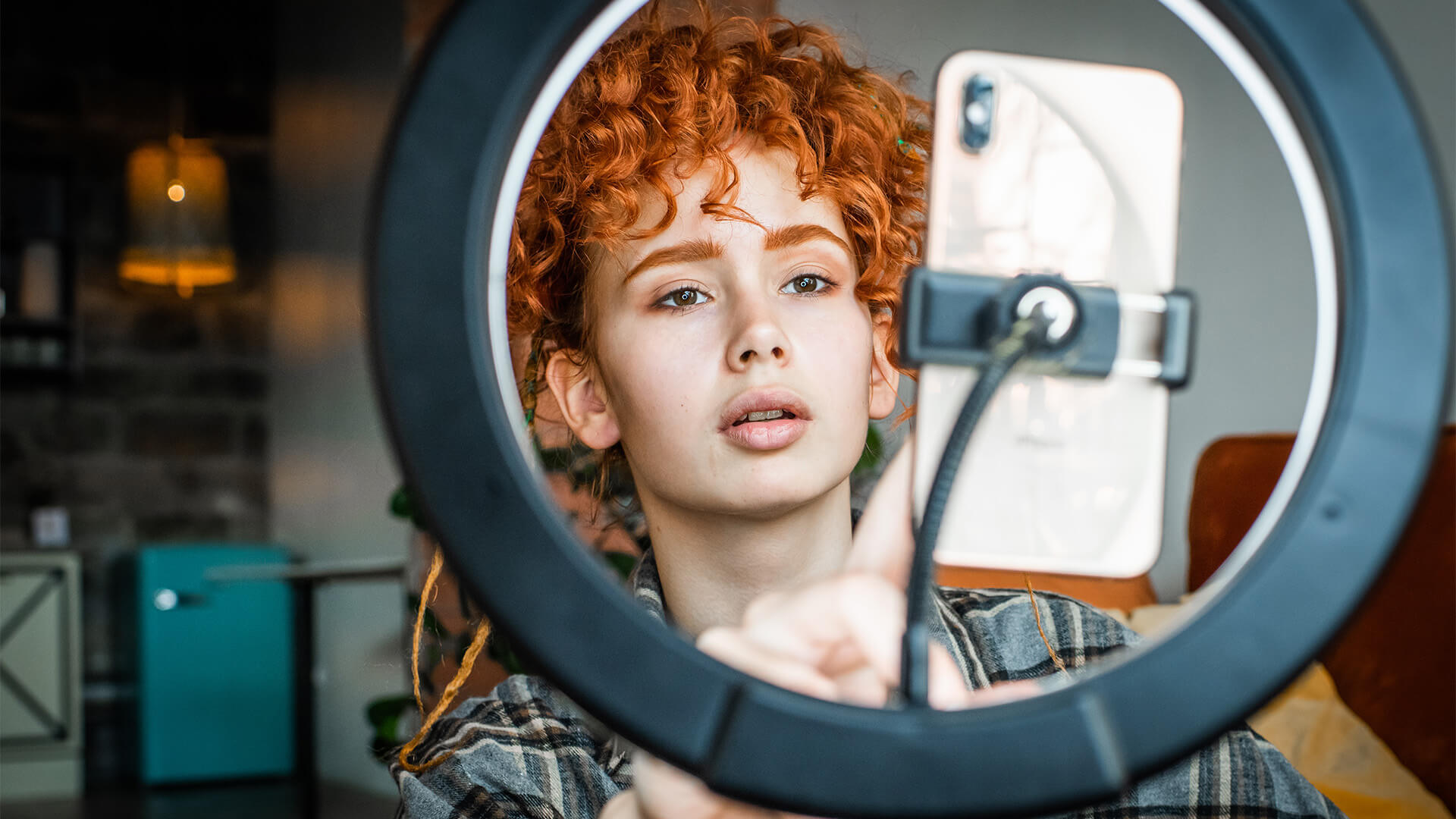 A woman films a video on a smartphone with a ring light