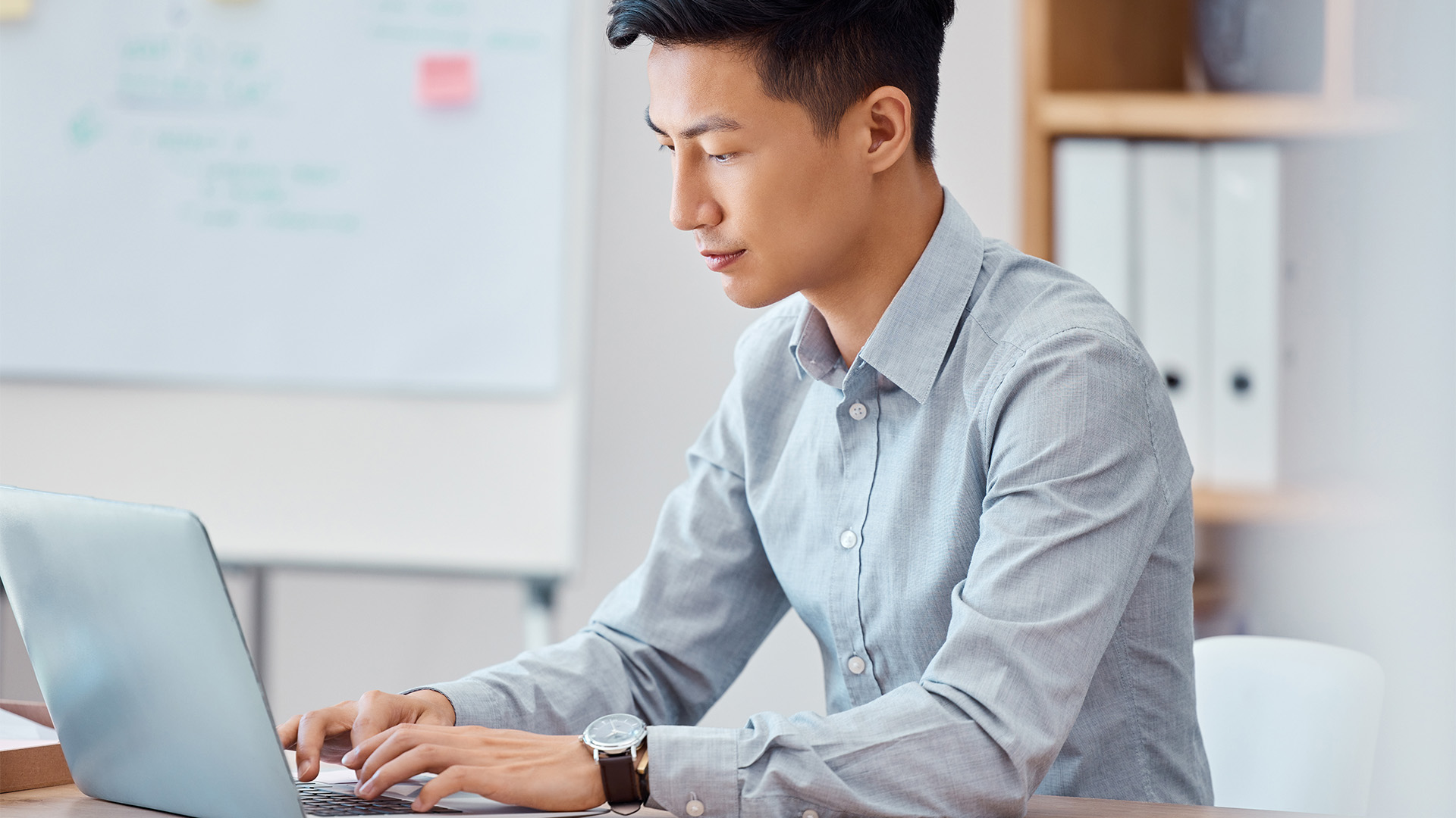 A man sitting down using his laptop.