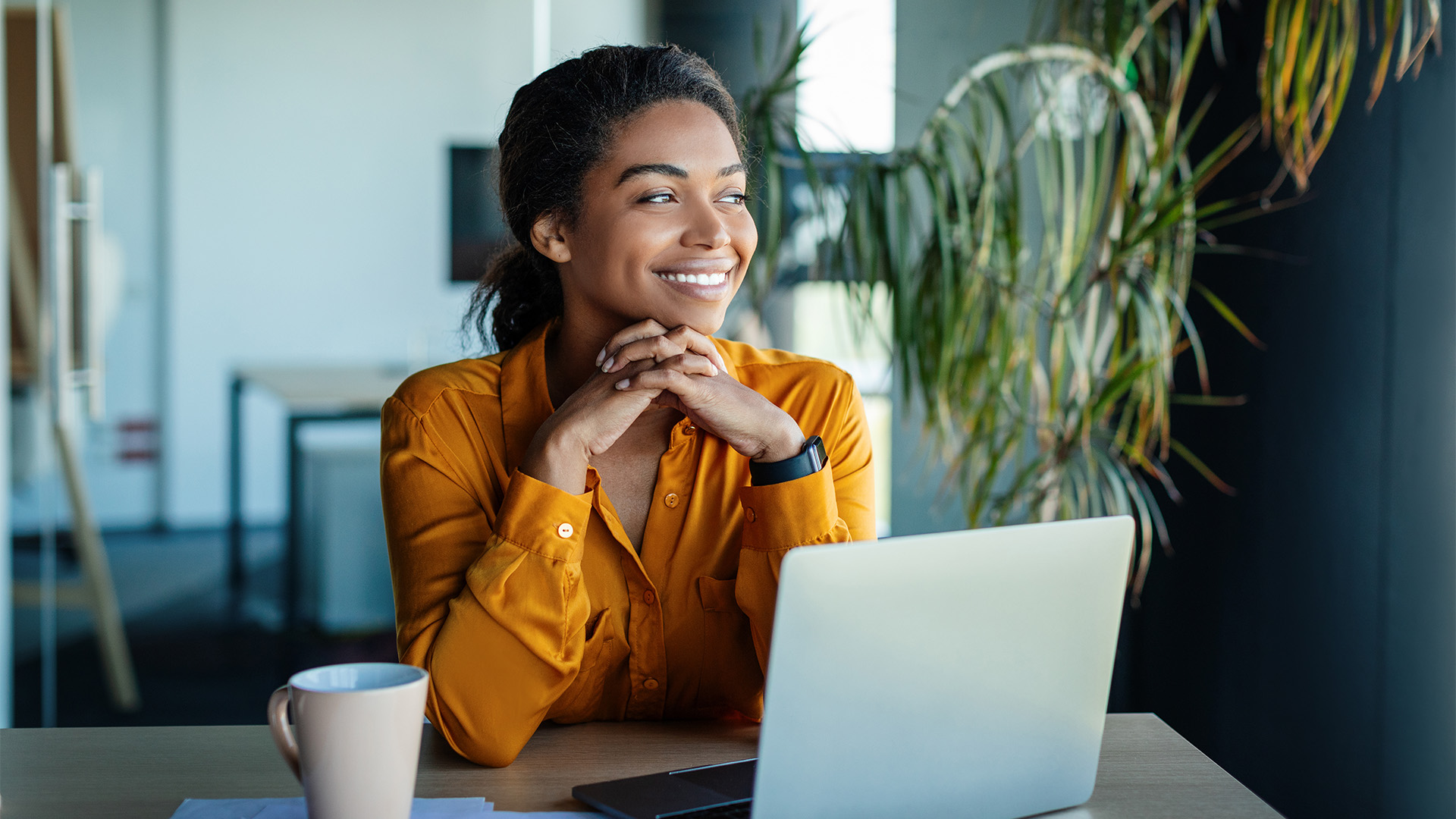 A woman working at her computer smiling.