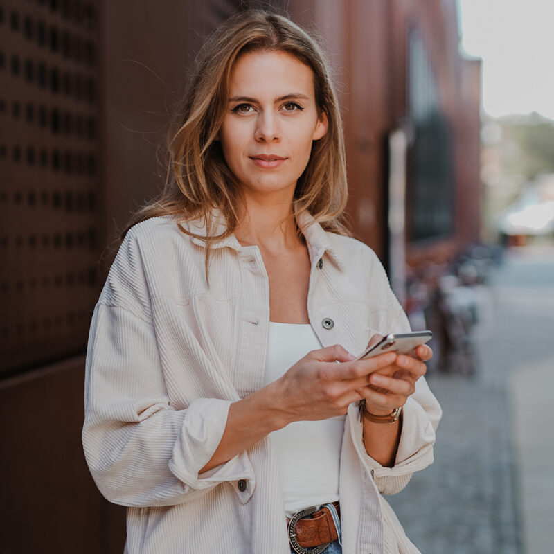 A woman poses on a street